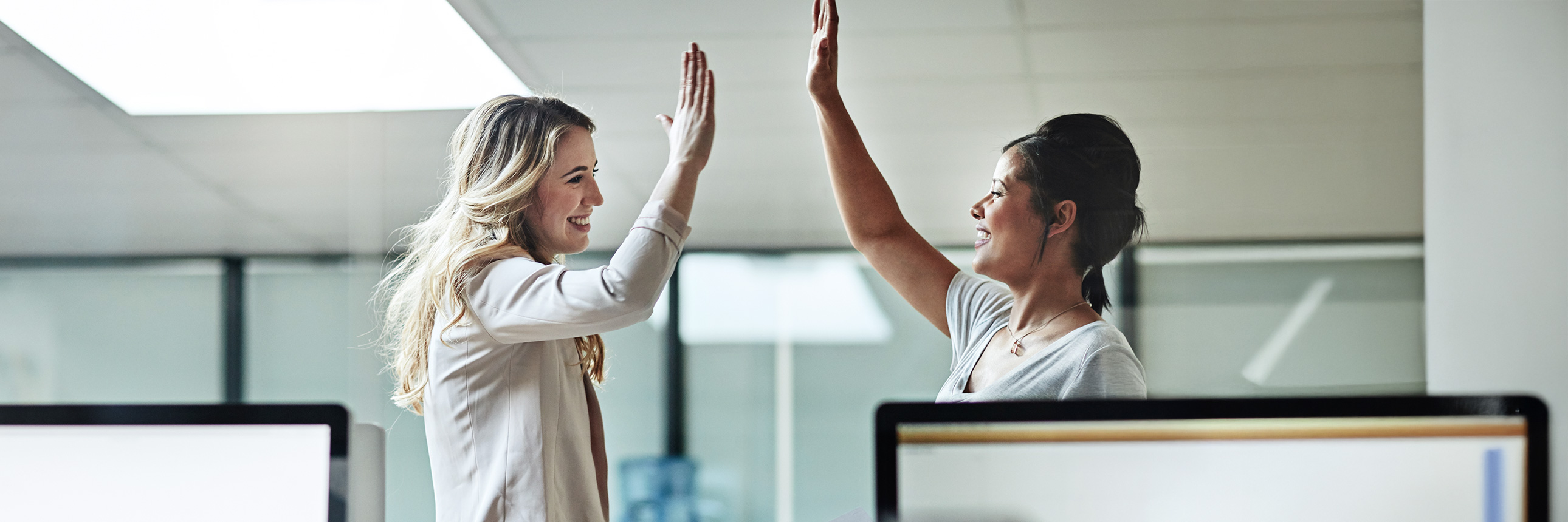 two people doing a high five while smiling