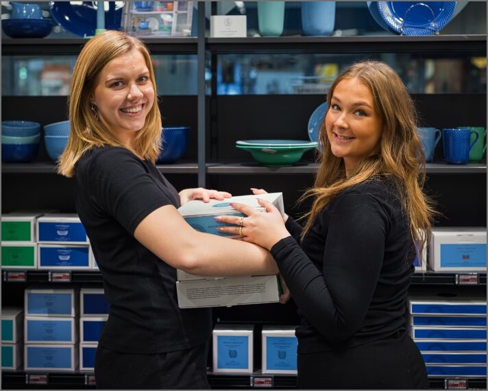 Malene og Emma bærer en kasse sammen