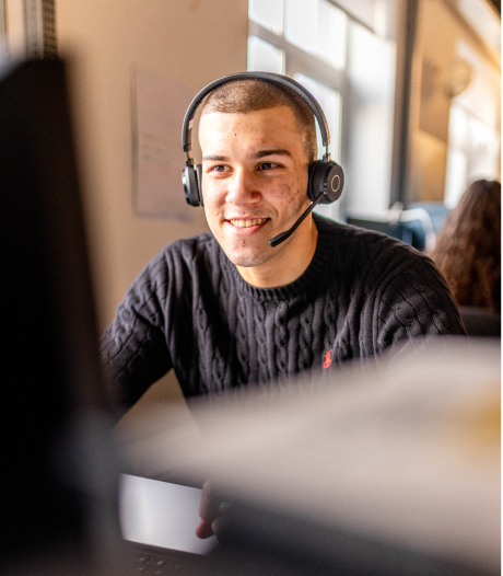 Fundraiser sidder foran computerskræm med headset på