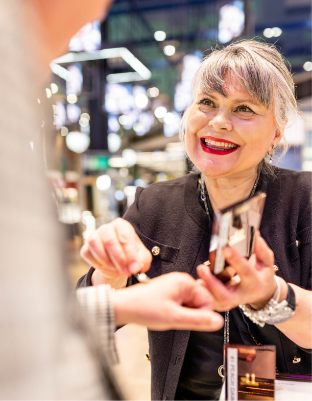 Medarbejder demonstrerer makeup for en kunde i Tax Free butik
