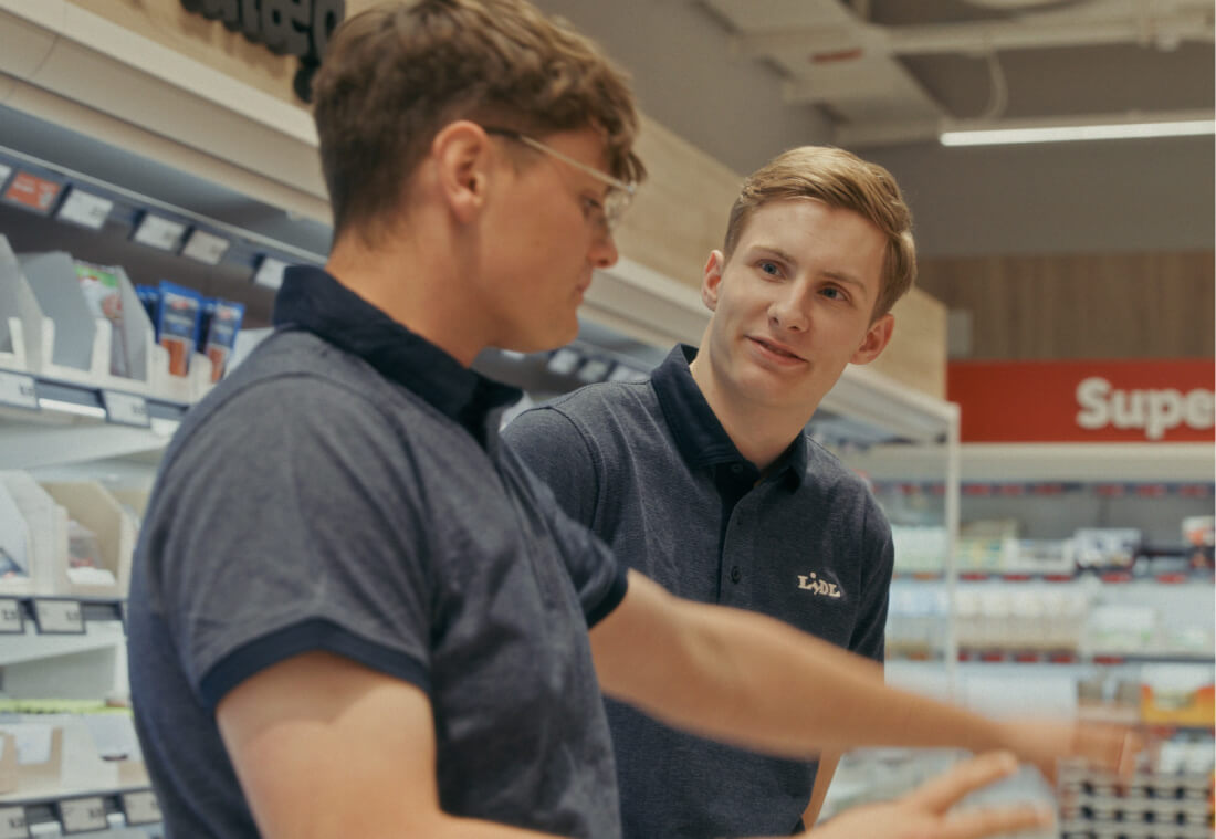 To Lidl-medarbejdere arbejder sammen over køledisken