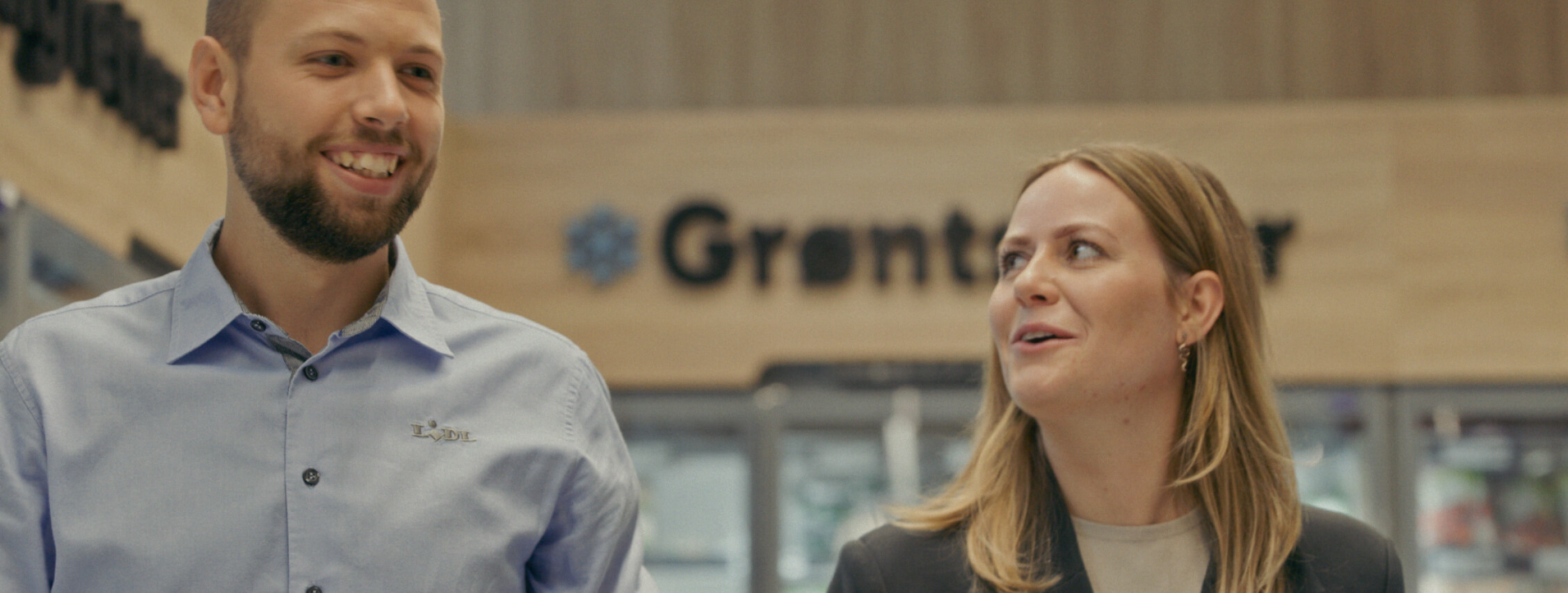 To Lidl-medarbejdere går side om side i en Lidl-butik