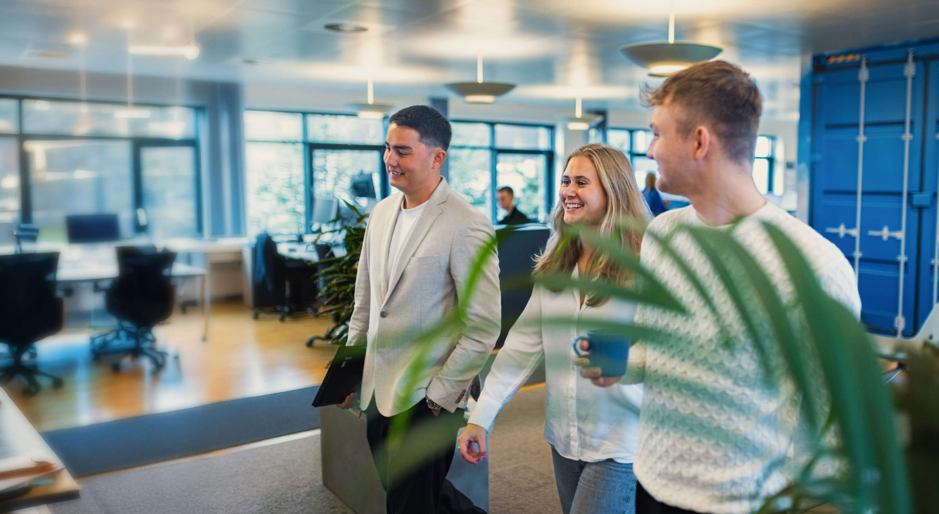 Tre elever går ned af gang på Kuehne + Nagel kontoret.