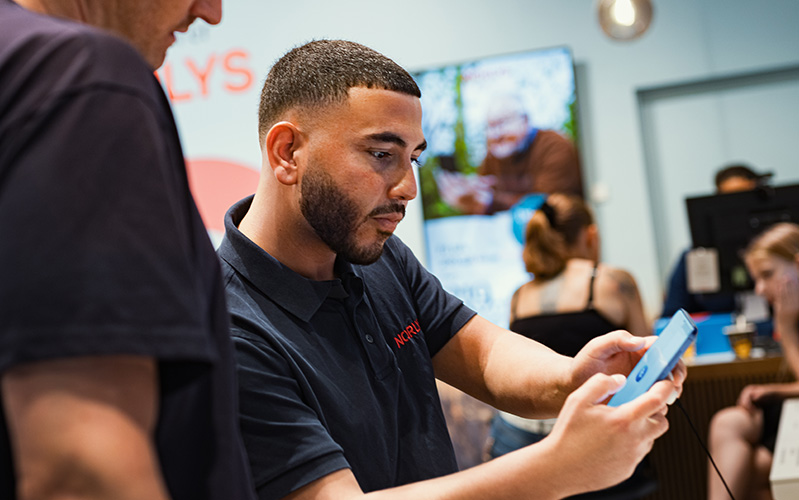 Billede af Laith der fortæller en kunde om en telefon