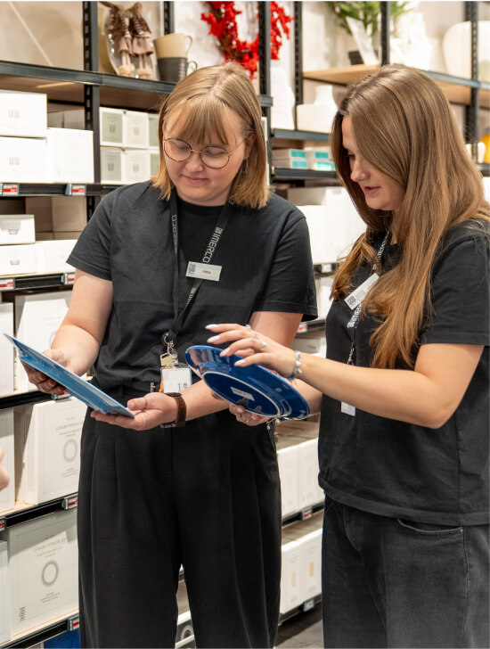 To Imerco elever står sammen og kigger på produkter i butikken.