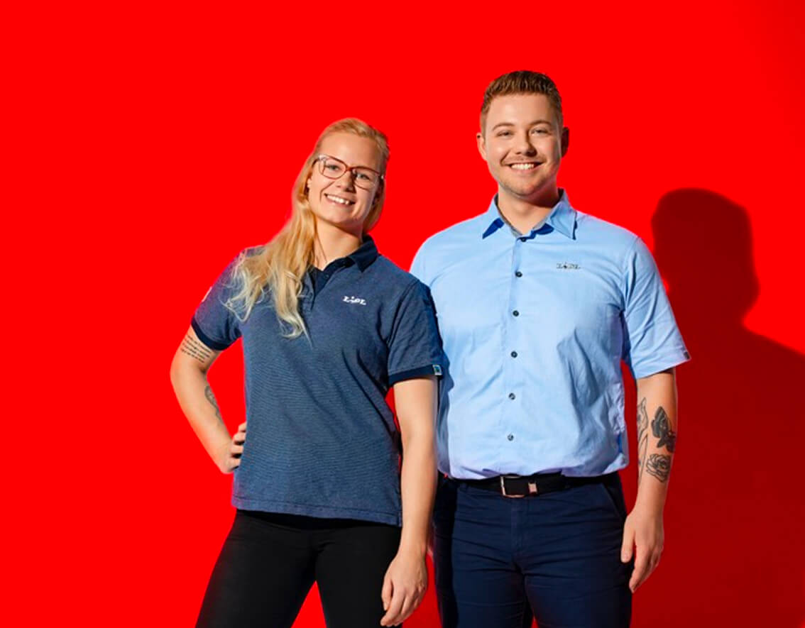 To Lidl-medarbejdere står ved siden af hinanden og smiler til kameraet