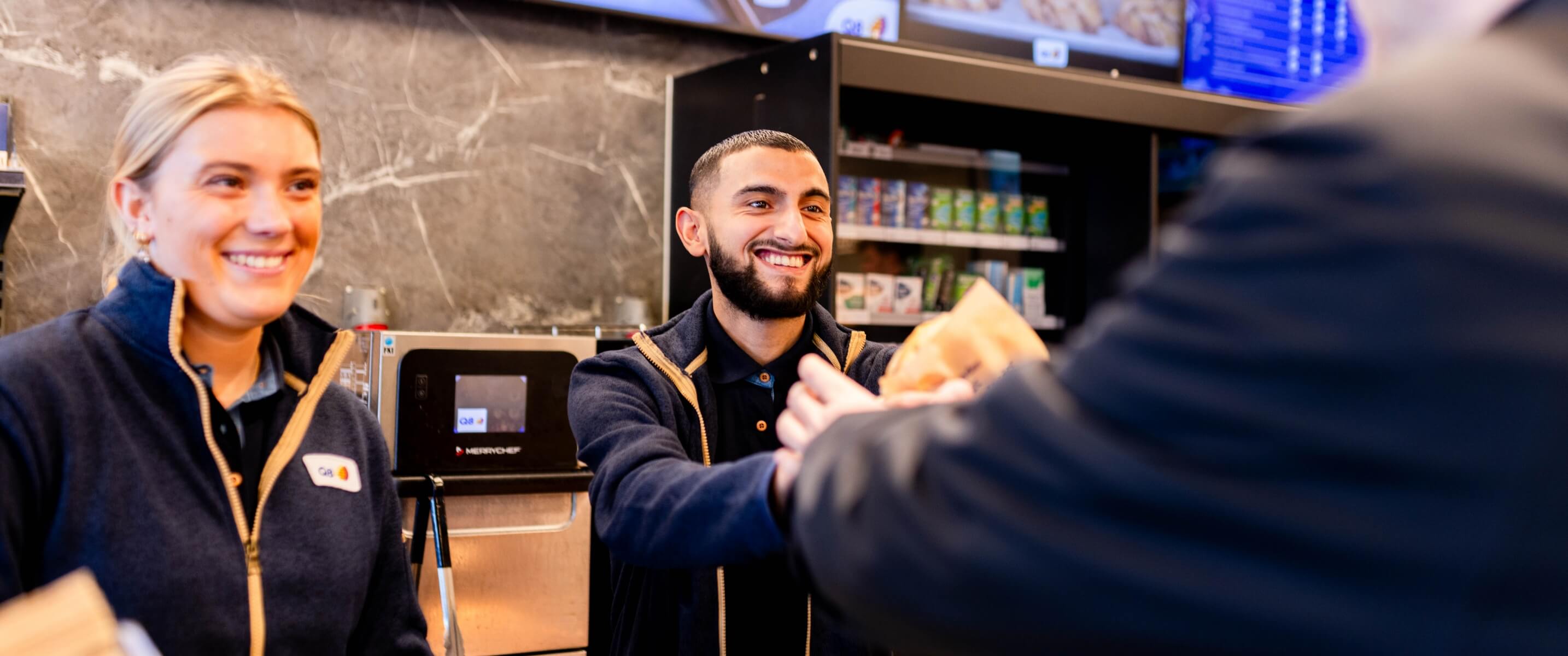 Billede af Görkem og Jasmina der ekspediere kunde i butikken
