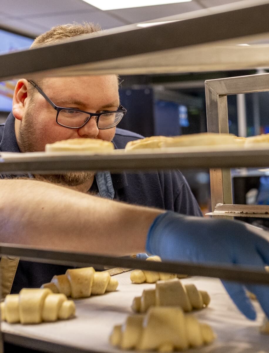 Billede af Martin der placerer croissant på bageplader