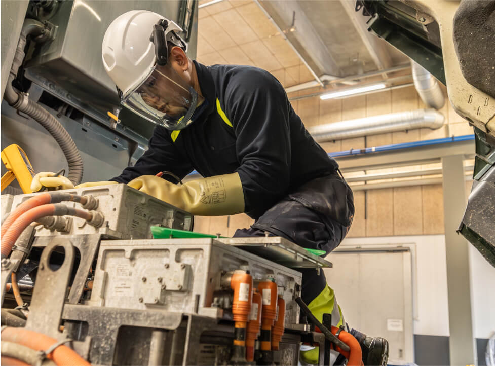 En mandlig mekaniker har sikkerhedsudstyr på og håndterer noget elektronik