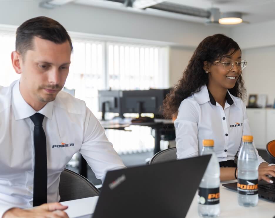 Sadia og kollega sidder foran skrivebord