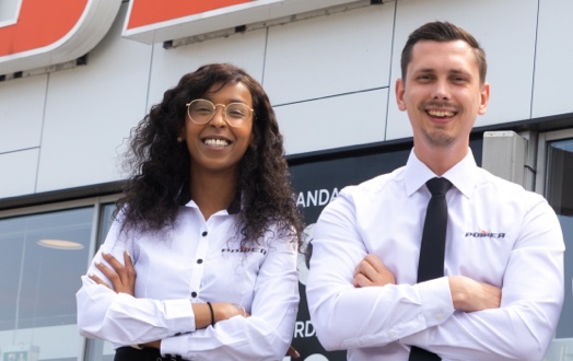 Smilende Sadia og kollega foran Power butik