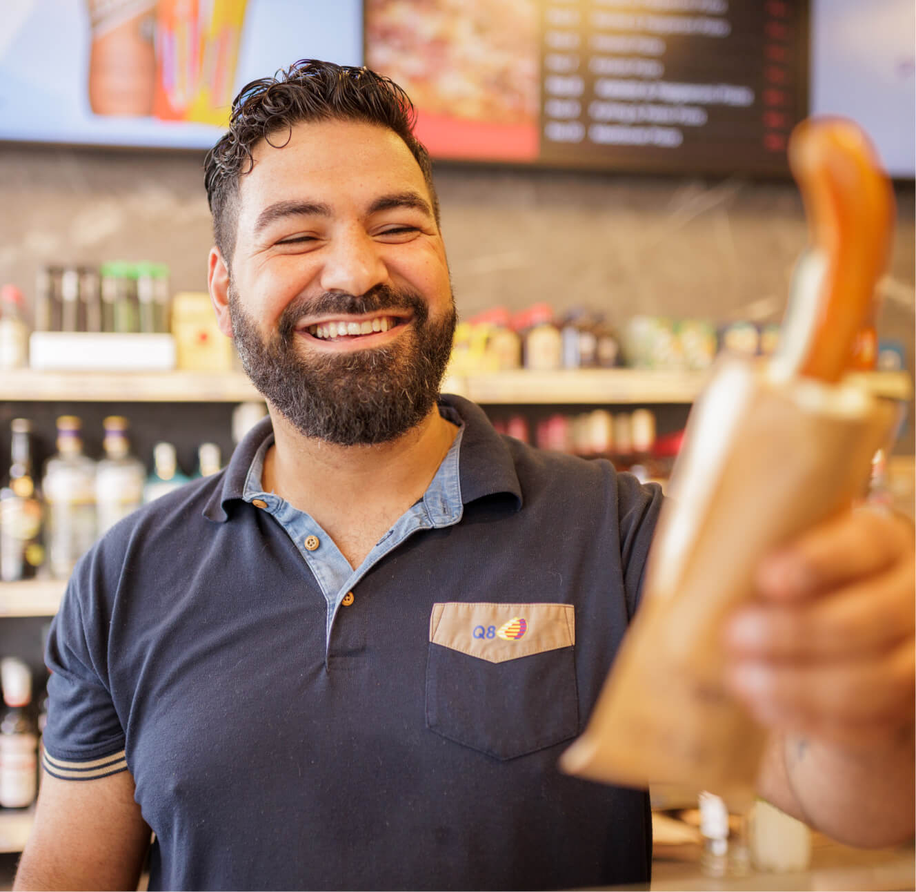 Vedat rækker en kunde en fransk hotdog.