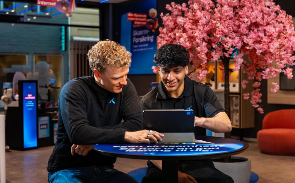 to smilende Telenor kolleger står i butik.