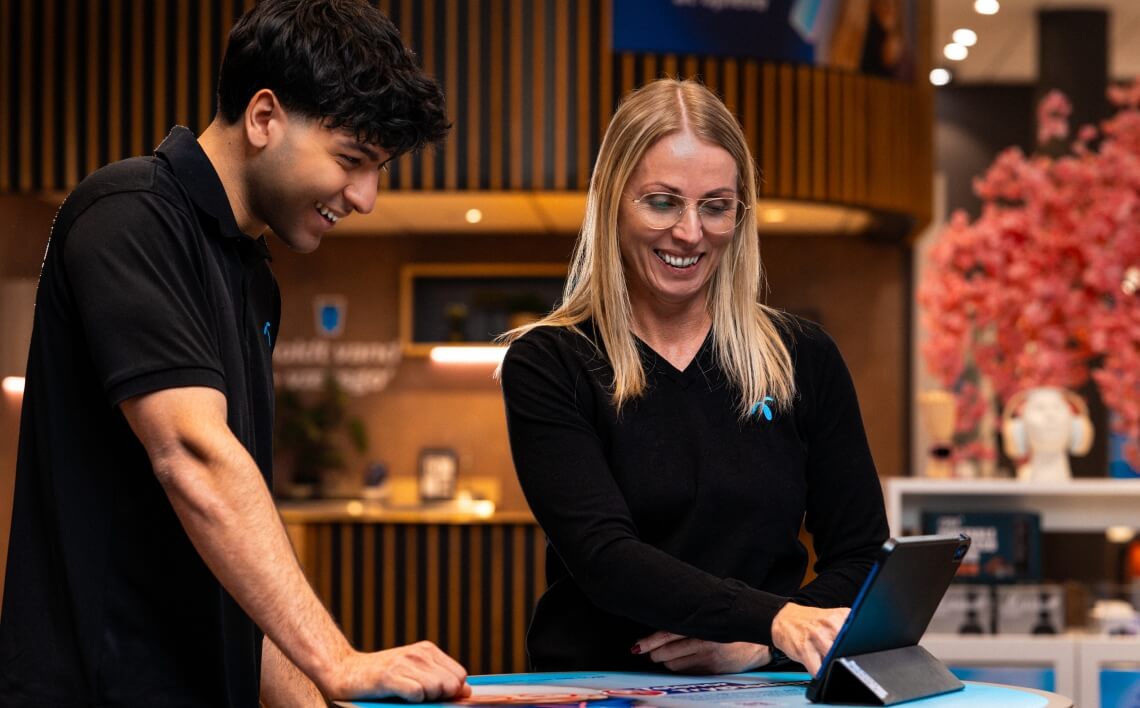 to smilende Telenor kolleger står i butik.