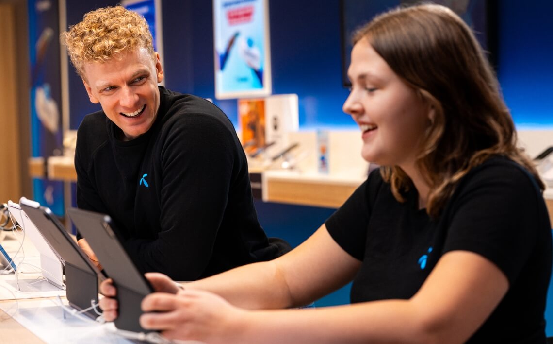 to smilende Telenor kolleger står i butik.