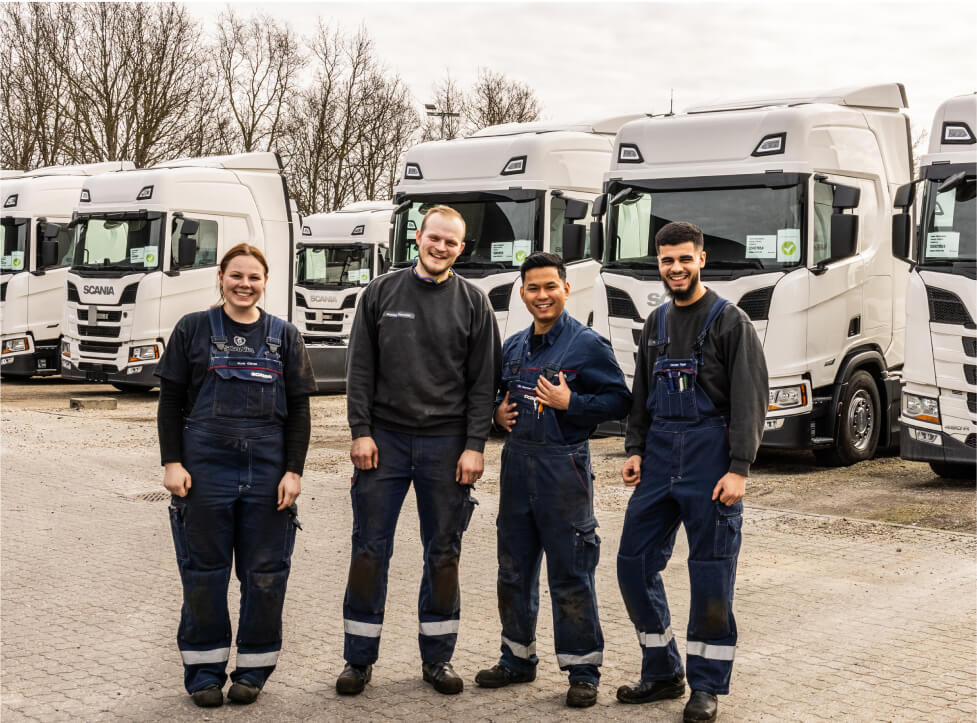 4 mekanikere poserer udenfor foran fire store Scania lastvogne