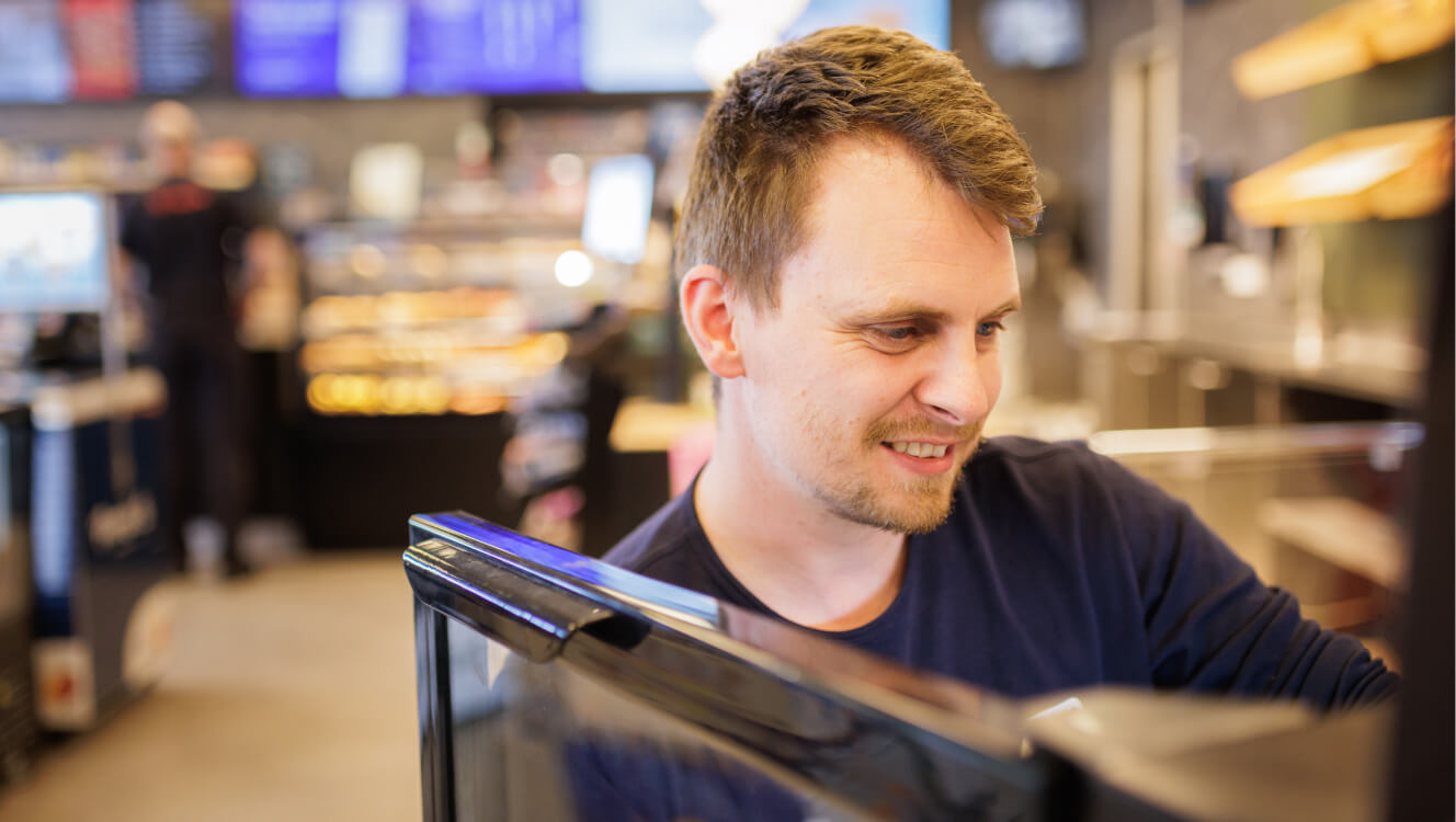 Medarbejder fylder op i butikken.