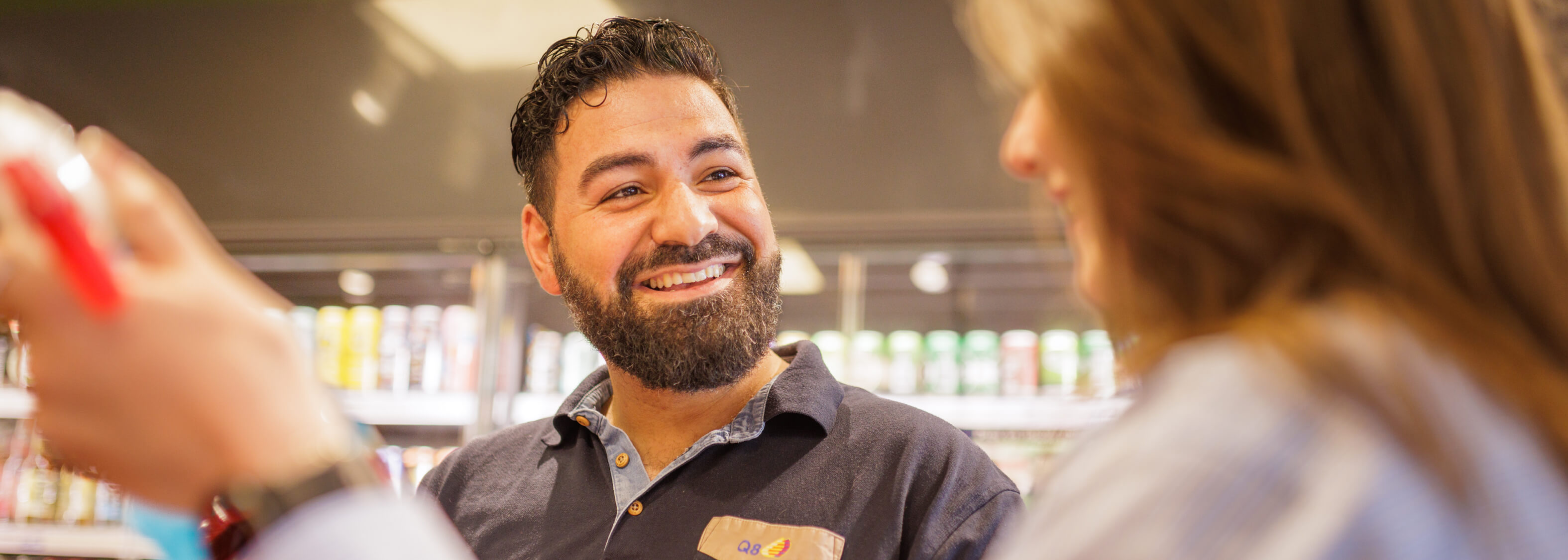Vedat betjener smilende en kunde.